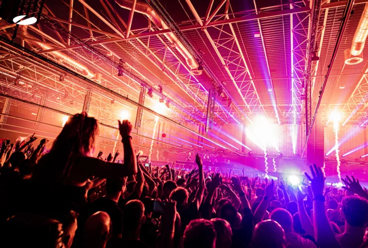 La foule en liesse devant la scène lors d’un événement A State Of Trance à l’Ahoy Rotterdam, sous un impressionnant dispositif de lumières et de lasers.