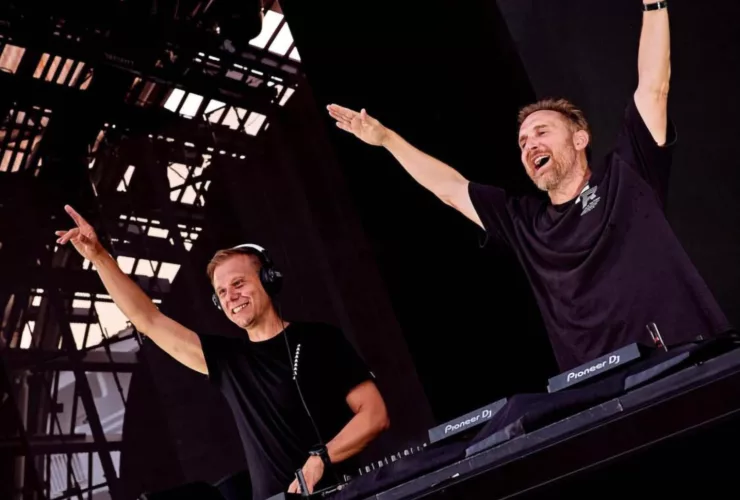 Armin van Buuren et David Guetta se produisant ensemble sur scène à l'Ushuaïa Ibiza, souriant et levant les bras.