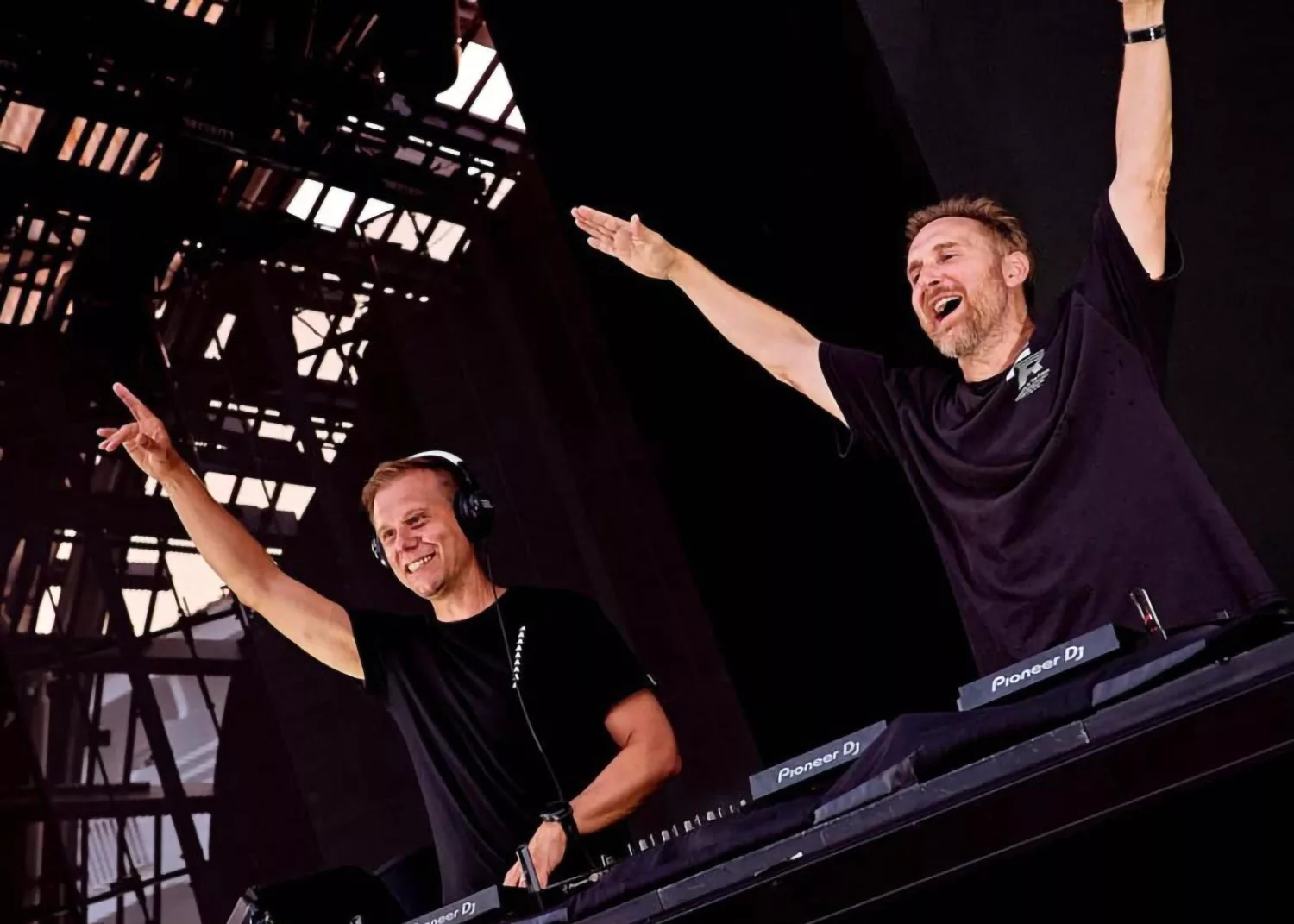 Armin van Buuren et David Guetta se produisant ensemble sur scène à l'Ushuaïa Ibiza, souriant et levant les bras.