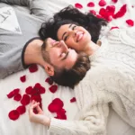 Couple couché sur la tête de lit avec la tête entourée de pétales de rose. Illustration pour notre playlist Trance & Progressive spéciale Saint-Valentin.