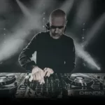 Photo de John 00 Fleming en plein DJ set, concentré derrière ses platines