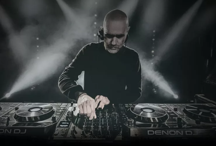 Photo de John 00 Fleming en plein DJ set, concentré derrière ses platines