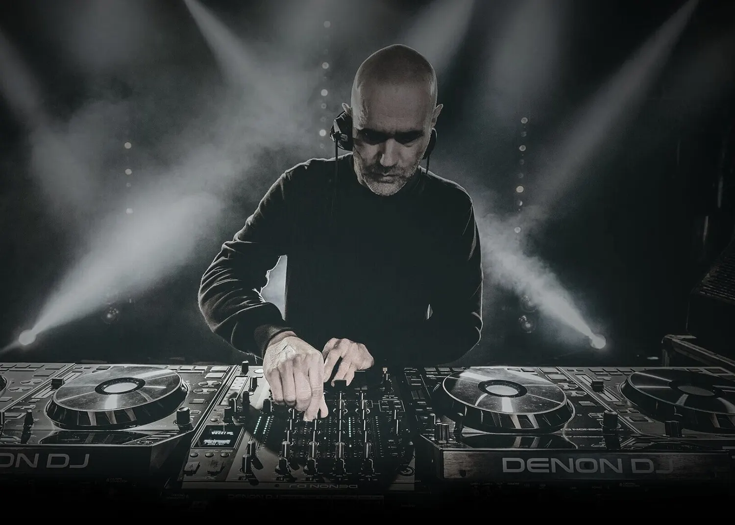Photo de John 00 Fleming en plein DJ set, concentré derrière ses platines