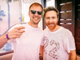 Armin van Buuren et David Guetta posant ensemble, souriants, avec Armin portant des lunettes de soleil.