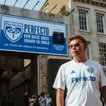 Paul Oakenfold posant devant le Karma Sanctum Hotel, à Soho (Londres), devant une affiche célébrant les 35 ans de Perfecto Records et le documentaire "Perfecto: How Dance Music Changed the World".