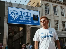 Paul Oakenfold posant devant le Karma Sanctum Hotel, à Soho (Londres), devant une affiche célébrant les 35 ans de Perfecto Records et le documentaire "Perfecto: How Dance Music Changed the World".