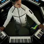 Giuseppe Ottaviani entouré de son dispositif scénique OTTAGON, un setup octogonal composé de claviers et contrôleurs lumineux.