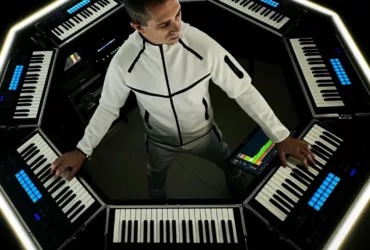 Giuseppe Ottaviani entouré de son dispositif scénique OTTAGON, un setup octogonal composé de claviers et contrôleurs lumineux.