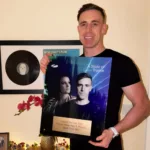 Bryan Kearney posant avec la plaque “Tune Of The Year 2025” d’A State Of Trance, attribuée à son titre “God Help Me” feat. Plumb.