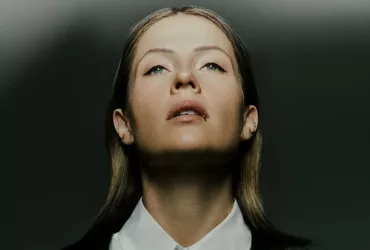 Portrait de Charlotte de Witte, regard tourné vers le haut, éclairée par une lumière contrastée sur fond sombre.