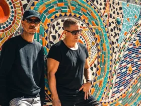 Le duo Cosmic Gate photographié devant une fresque en mosaïque colorée, dans une ambiance ensoleillée.