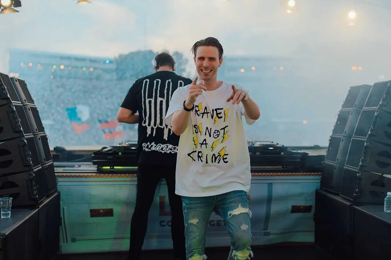 W&W sur scène à Tomorrowland, avec Willem van Hanegem au premier plan pointant vers le photographe et Wardt van der Harst derrière les platines.