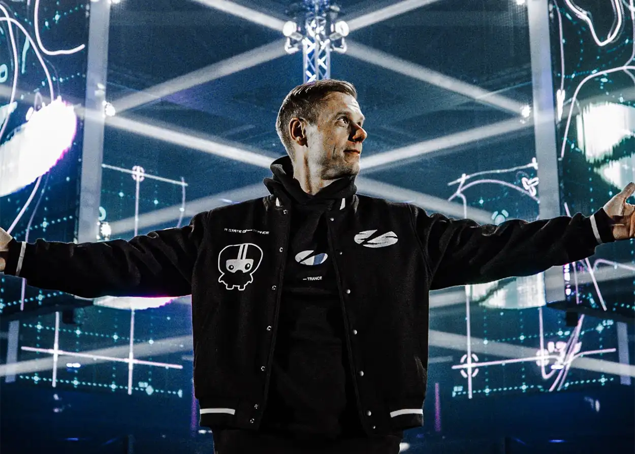 Armin van Buuren les bras ouverts au centre de la scène entourée d’écrans LED et de faisceaux lumineux, avant l’ouverture des portes de l’événement célébrant les 25 ans d’A State Of Trance à l’Ahoy Rotterdam.