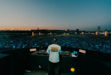 Tiësto joue face à une foule immense lors de son set à Silverworks Island en 2026, au coucher du soleil, derrière ses platines.