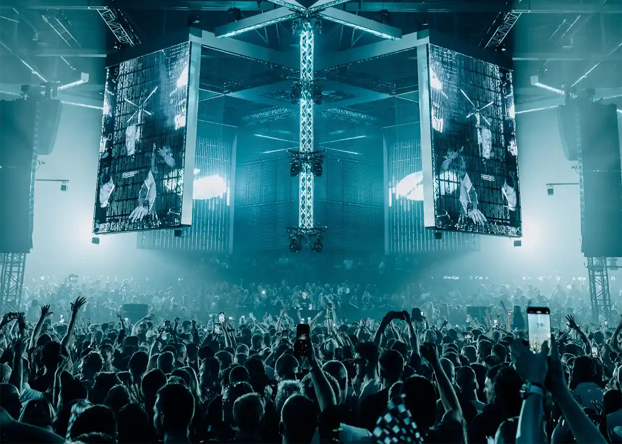 A State Of Trance 2026 à Rotterdam, avec une foule immense face à la scène centrale et ses écrans géants dans une ambiance lumineuse bleutée.