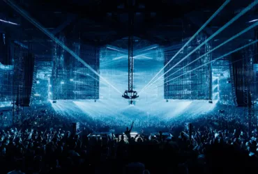 A State Of Trance 2026 au Rotterdam Ahoy, avec une foule immense face à la scène centrale sous des faisceaux laser bleus et de grands écrans suspendus.