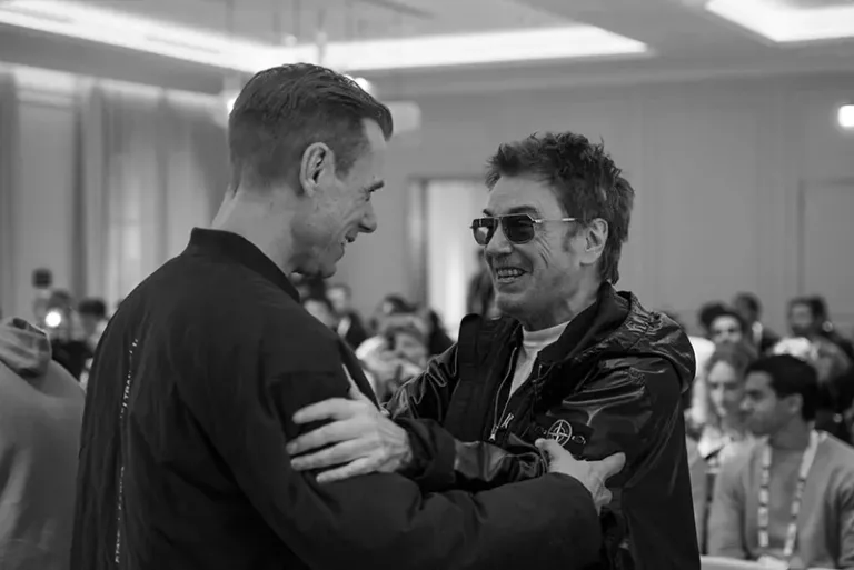 Armin van Buuren et Jean-Michel Jarre se retrouvent à l’ADE 2026, échangeant un sourire et une accolade sur une photo en noir et blanc.